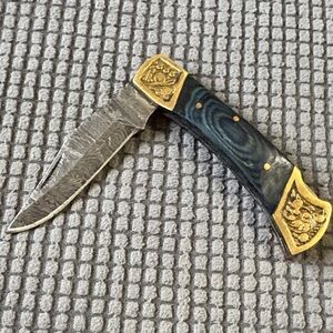Deco Folding Pkt Knife with Blue Wood Handle and Gold. Blade is Damascus Steel.